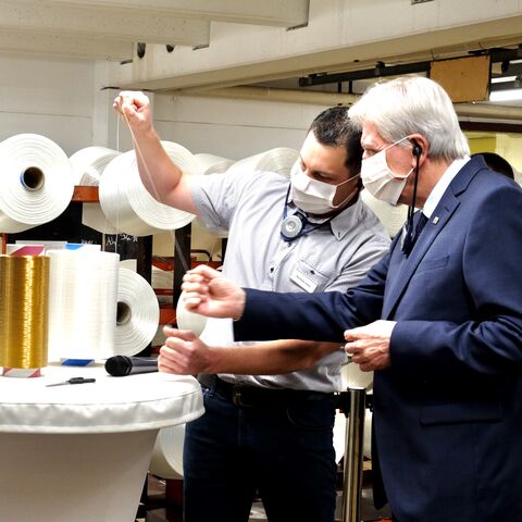 Besuch The Filament Factory in Bad Hersfeld Ministerpräsident Bouffier hält den Faden einer Spule.