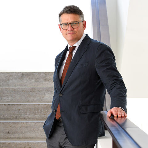 Boris Rhein Boris Rhein steht auf einer Treppe, an das Treppengeländer angelehnt.